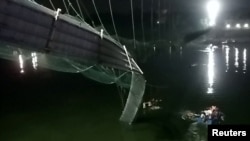 La foto muestra un sector dañado del puente de suspensión después de desplomarse en el poblado de Morbi, India, el 30 de noviembre de 2022.