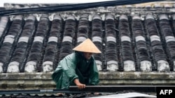 A resident consolidates the roof of house before typhoon Noru slams Vietnam, in Hoi An, Quang Nam province, on September 27, 2022. 