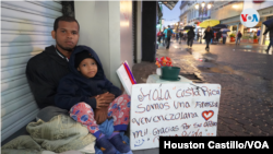 Un migrante venezolano junto a su hijo en una calle céntrica de San José, Costa Rica. Foto: Houston Castillo, VOA