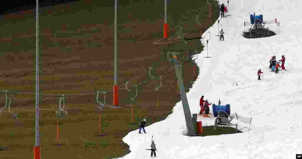 People enjoy the day at a ski hill prepared with artificial snow in Ruhpolding, southern Germany. Temperatures in southern Germany, are unusually high.