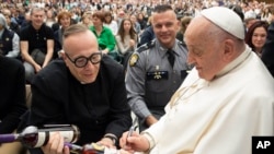 El papa Francisco autografía una botella de bourbon que sostiene el sacerdote católico de Kentucky reverendo Jim Sichko en el Vaticano el 1 de mayo de 2024. 