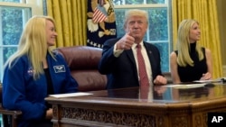 Presiden AS Donald Trump, didampingi astronot NASA Kate Rubins (kiri) dan putrinya Ivanka Trump ketika melakukan konferensi video dengan astronot NASA di Stasiun Antariksa Internasional (ISS) 24 April lalu (foto: ilustrasi). Trump menandatangani instruksi untuk memerintahkan NASA menghidupkan kembali program eksplorasi antariksa berawak, Senin (11/12). 