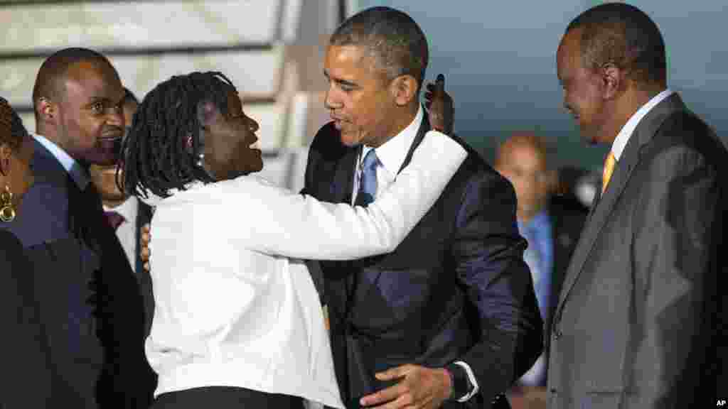 Rais wa Kenya, Uhuru Kenyatta, kulia, akiangalia huku Rais Barack Obama, katikati akimkubatia dada yake wa kambo, Auma Obama mara baada ya kuwasili kwenye uwanya wa ndege wa kimataifa wa Kenyatta, Ijumaa, Julai 24, 2015. Obama anayatembelea mataifa mawili ya Afrika ambako atakuwa ni rais wa kwanza wa Marekani aliye madarakani kuitembelea Kenya na Ethiopia.