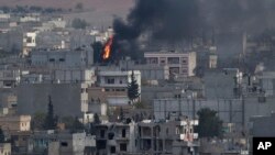 Kebakaran di kota Kobani, Suriah, dilihat dari atas bukit di luar kota Suruc, perbatasan Turki dan Suriah (13/11).