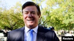 Paul Manafort sonríe al salir de la Corte de Distrito en Washington luego de escuchar los cargos en su contra derivados de la investigación de un fiscal especial sobre la posible interferencia rusa en las elecciones presidenciales de 2016. Oct. 30, 2017. 