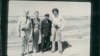 The black and white group photograph shows Richard Dudman (far left), Malcolm Caldwell (far right) and Elizabeth Becker (center left), with Commander Pin (center right), a senior Khmer Rouge military figure, near the eastern border with Vietnam preparing for war. (Courtesy photo of Elizabeth Becker)