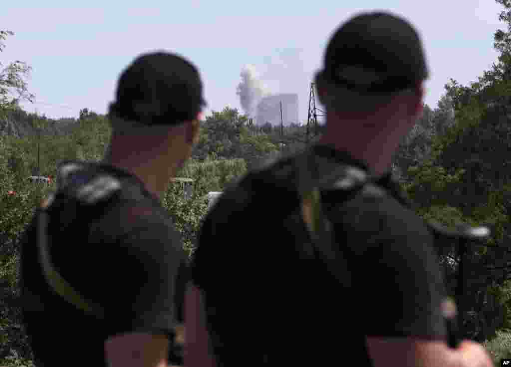 Self-proclaimed Donetsk People's Republic policemen watch shelling in Shakhtarsk, Donetsk region, eastern Ukraine, July 28, 2014.