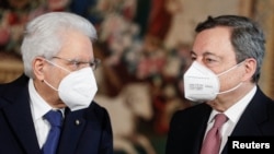 Predsednik Italije Serđo Matarela i premijer Mario Dragi, noseći maske na licu, razgovaraju nakon ceremonije polaganja zakletve za nove ministre, u predsedničkoj palati u Rimu, Italija, 13. februara 2021.