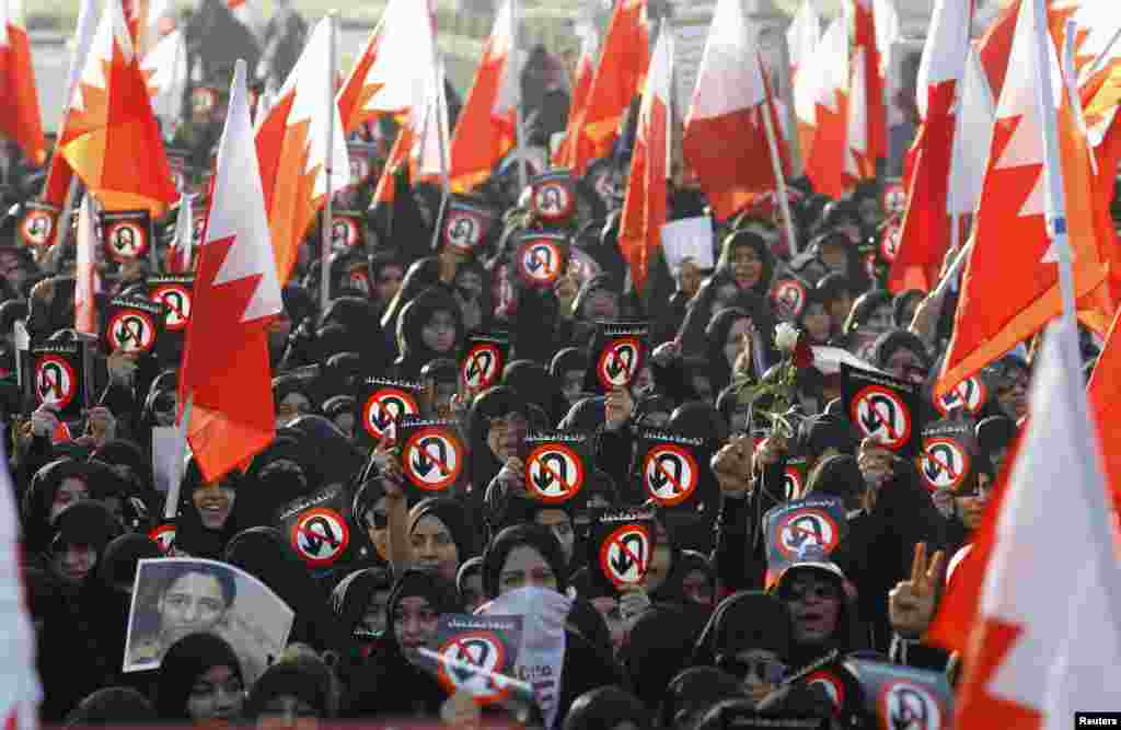 Para pengunjuk rasa memegang bendera Bahrain dan spanduk-spanduk dalam reli yang diselenggarakan oleh kelompok oposisi Al Wefaq, di Budaiya, sebelah barat Manama, Bahrain.