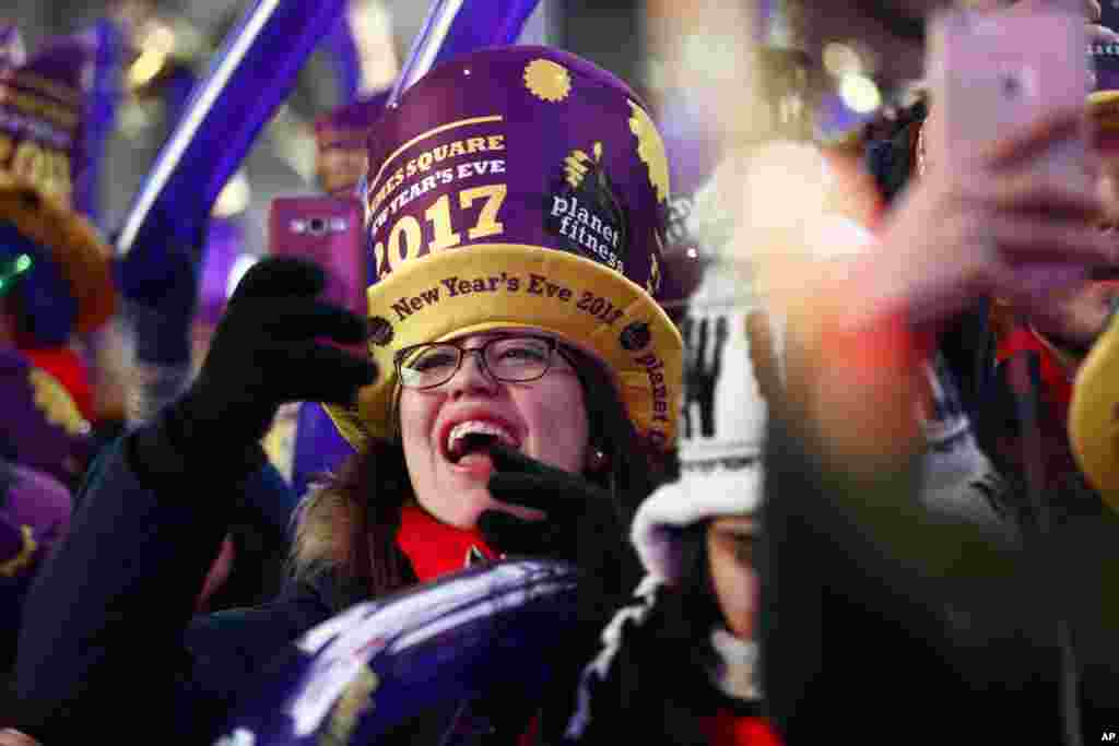 A reveler sings along to a musical act during the New Year's Eve celebration at Times Square, Dec. 31, 2016, in New York.
