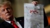 President Donald Trump shows maps of Syria and Iraq depicting the size of the "ISIS physical caliphate" as he speaks to workers at the country's only remaining tank manufacturing plant, in Lima, Ohio, March 20, 2019. 