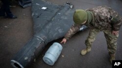 Український офіцер показує термобаричний заряд збитого безпілотника Shahed, запущеного Росією, у дослідницькій лабораторії в Україні, 14 листопада 2024 р. AP Photo/Efrem Lukatsky