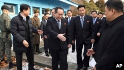 北韓和平統一委員會主席李善權（中）在板門店非軍事區走過邊界時與迎接他的南韓官員握手（2018年1月9日）