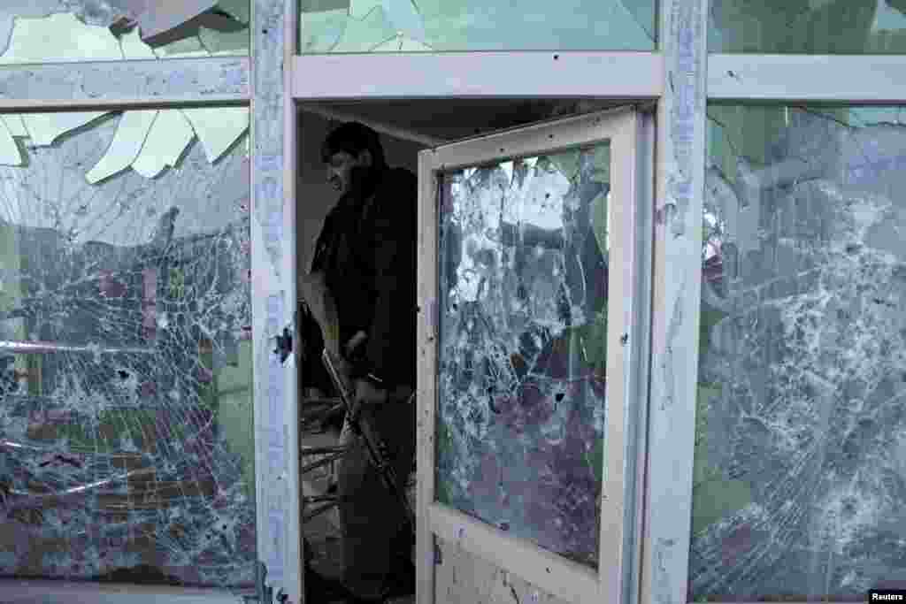 An Afghan policeman inspects a building used by insurgents after an operation near the Indian consulate in Mazar-i-Sharif. Afghan special forces killed a group of insurgents holed up in a house in the northern city of Mazar-i-Sharif, bringing to an end a 24-hour siege following the insurgents' attack on the nearby Indian consulate.