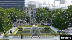 Doves fly over the Peace Memorial Park with a view of the gutted A-bomb dome at a ceremony in Hiroshima, Japan, Aug. 6, 2010. 