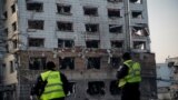Сотрудники полиции осматривают поврежденное здание после ракетного обстрела в Киеве 12 февраля 2025 года