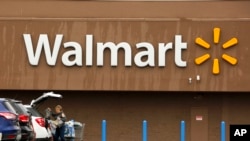 A shopper loads her car after shopping at a Walmart in Pittsburgh, Feb. 22, 2018. 