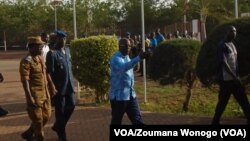 Le ministre de la Sécurité du Burkina Faso, Simon Compaore, à droite, visite le site d'une attaque contre un poste de police dans le village d'Intagom, 1er juin 2016.