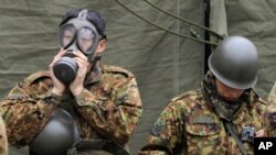 Soldats japonais se préparant pour le nettoyage de zones ayant subi des radiations nucléaires à Fukushima.