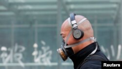 Seorang pria menggunakan masker di jalanan Beijing akibat pencemaran udara yang parah, Mei 2013. (Foto: Dok)