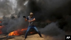 A Palestinian protester hurls stones at Israeli troops during clashes along Gaza's border with Israel, east of Khan Younis, Gaza Strip, April 20, 2018. 