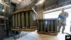 Американський військовий перевіряє піддони зі 155-мм снарядами. Західні партнери надали мільйони цих боєприпасів Україні від повномасштабного вторгнення Росії у лютому 2022 року. (Фото: AP/Алекс Брендон)