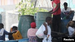 ARCHIVO: La gente se reúne para comprar gasolina mientras la violencia se propaga y las bandas armadas amplían su control sobre la capital, en Puerto Príncipe, Haití, el 29 de marzo de 2024. 