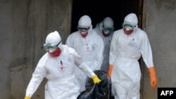 Petugas kesehatan Palang Merah Liberia menggunakan pakaian pelindung ketika mengangkut jenazah penderita ebola, di Banjol, Monrovia (4/9/2014).