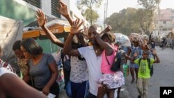 ARCHIVO - Vecinos huyen de sus casas durante los enfrentamientos entre la policía y miembros de una pandilla en el barrio de Portail en Puerto Príncipe, Haití, el jueves 29 de febrero de 2024.