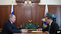Le président russe Vladimir Poutine, à gauche, s'entretient avec le Premier ministre russe Dmitri Medvedev lors de leur réunion à Moscou, en Russie, 10 avril 2018.