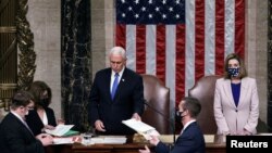 FILE - U.S. Vice President Mike Pence hands the West Virginia certification to staff as Speaker of the House Nancy Pelosi listens, during a joint session of Congress, Jan. 7, 2021.