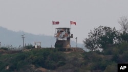 FILE - Flags flutter in the wind at a military guard post in Paju, South Korea, at the border with North Korea, May 3, 2020.