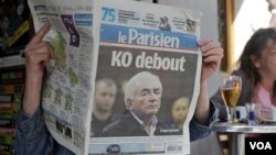 Una mujer lee el diario franceses "Le Parisien", cuya primera página muestra noticias sobre el director gerente del FMI.