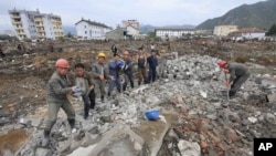 Para pekerja memperbaiki lokasi yang hancur akibat banjir di Onsong, provinsi Hamgyong Utara, Korea Utara, 16 September 2016. (AP Photo/Kim Kwang Hyon)