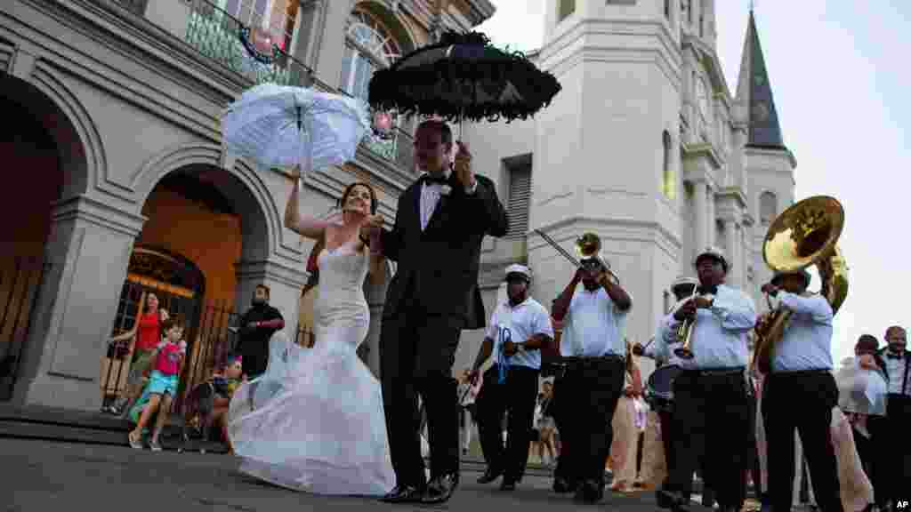 Un couple danse au son de la fanfare au sortir de la cathédrale Saint-Louis à Jackson Square dans le quartier français de la Nouvelle Orléans, reflétant l'image de la joie de vivre revenue à la Nouvelle Orléans, le samedi 15 août 2015