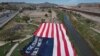 Migrantes venezolanos portan una inmensa bandera de EEUU en una protesta contra la nueva política de inmigración de Estados Unidos cerca del Río Bravo en Cuidad Juárez, México, el 31 de octubre de 2022.
