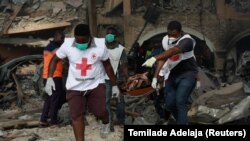 Des ambulanciers transportent une civière contenant une victime d'un des bâtiments effondrés sur la scène de l'explosion d'un pipeline à Lagos, au Nigeria, le 15 mars 2020. (Photo: REUTERS/Temilade Adelaja)