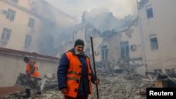 Los trabajadores municipales retiran los escombros fuera de la sede de la administración ferroviaria local dañada por los bombardeos en el curso del conflicto entre Rusia y Ucrania en Donetsk, Ucrania controlada por Rusia, el 7 de noviembre de 2022. REUTERS/Alexander Ermochenko