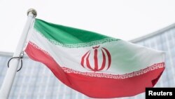Bendera Iran berkibar di depan gedung International Center dengan markas Badan Tenaga Atom Internasional, IAEA, di Wina, 24 Mei 2021. (Foto: AP)