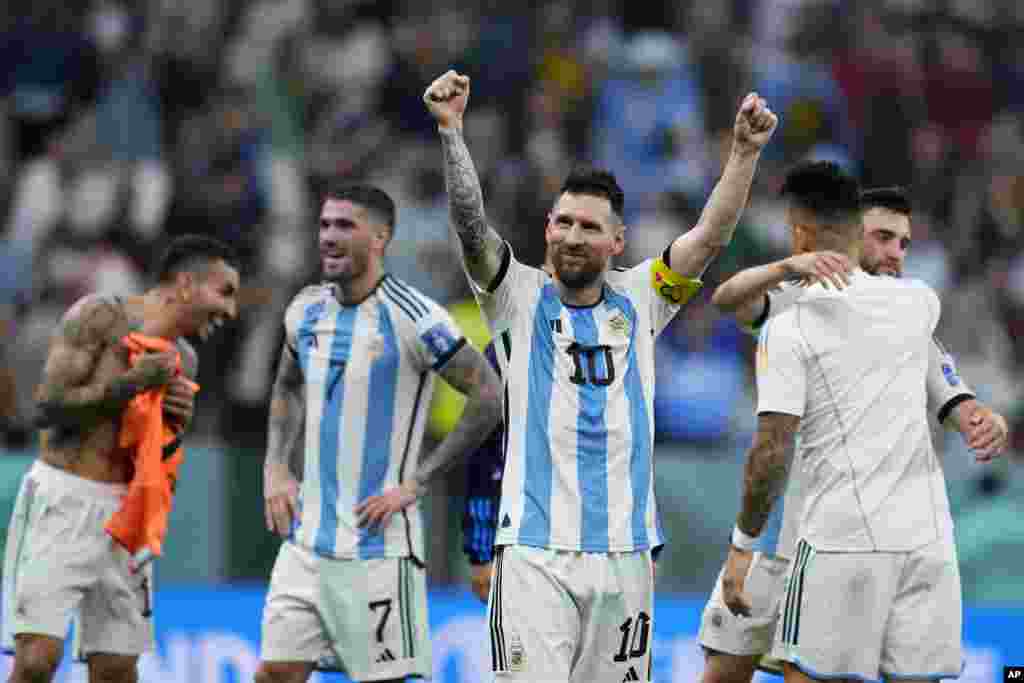Lionel Mess atomboli maboko na kosepela na baninga baye ba ekipi ya Argentine nsima na kolonga Croatie 3-0 na 1/2 finale ya Mondial Qatar 2022 na stade Lusail, Doha, 13 décembre 2022. (AP Photo/Natacha Pisarenko)