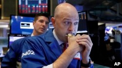 Specialists Jay Woods, right, and Thomas McArdle work on the floor of the New York Stock Exchange, Oct. 11, 2018. 
