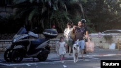 Los israelíes reaccionan en una calle mientras se lanzan ataques con cohetes desde la Franja de Gaza, en Tel Aviv, Israel, el 7 de octubre de 2023. [REUTERS]