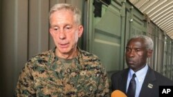 FILE - Gen. Thomas D. Waldhauser, left, commander of U.S. Africa Command, is joined by U.S. Ambassador to Senegal Tulinabo S. Mushingi, right, while speaking during a tour of a cooperative security location Camp Cisse.