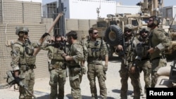 Tentara Pasukan Khusus AS berbicara satu sama lain sebelum mereka meninggalkan pangkalan mereka di Helmand, Afghanistan, 28 September 2015. (Foto: dok).