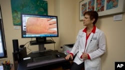 Dr. Anne Burdick, spesialis kulit dari University of Miami memeriksa layar komputer di kantornya di Miami, seraya berdiskusi mengenai telemedicine (8/4/2014) (foto: dok)