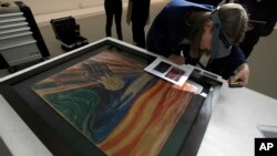 Un conservateur examine un tableau lors d’une exposition à la Fondation Vuitton, au musée d’Oslo, à Paris, France, 6 juillet 2015.