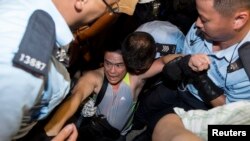 一名參與預演佔中的學生遭清場的警察抬離現場。