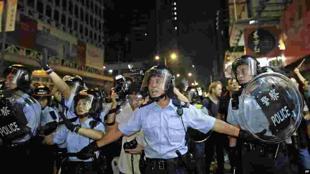 Riot police advance on a pro-democracy protest encampment in the Mong Kok district of Hong Kong early, Oct. 19, 2014.