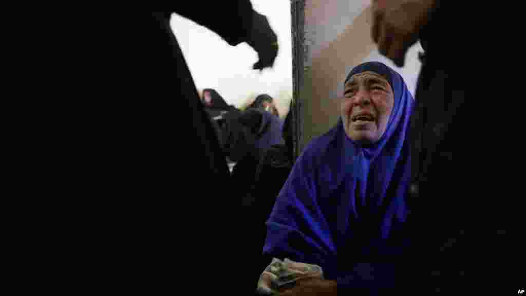 A woman mourns over Egyptian Coptic Christians who were beheaded by the Islamic State group at the Virgin Mary Church in the village of el-Aour, near Minya, 220 kilometers (135 miles) south of Cairo, Egypt, Feb. 16, 2015.