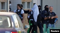 ماموران پلیس نزدیک شهر لیون روی صورت یاسین صالحی، ۳۵ ساله را پوشانده و او را با خود می برند. ۲۸ ژوئن ۲۰۱۵